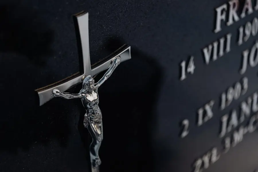 Polished crucifix and lettering on black granite