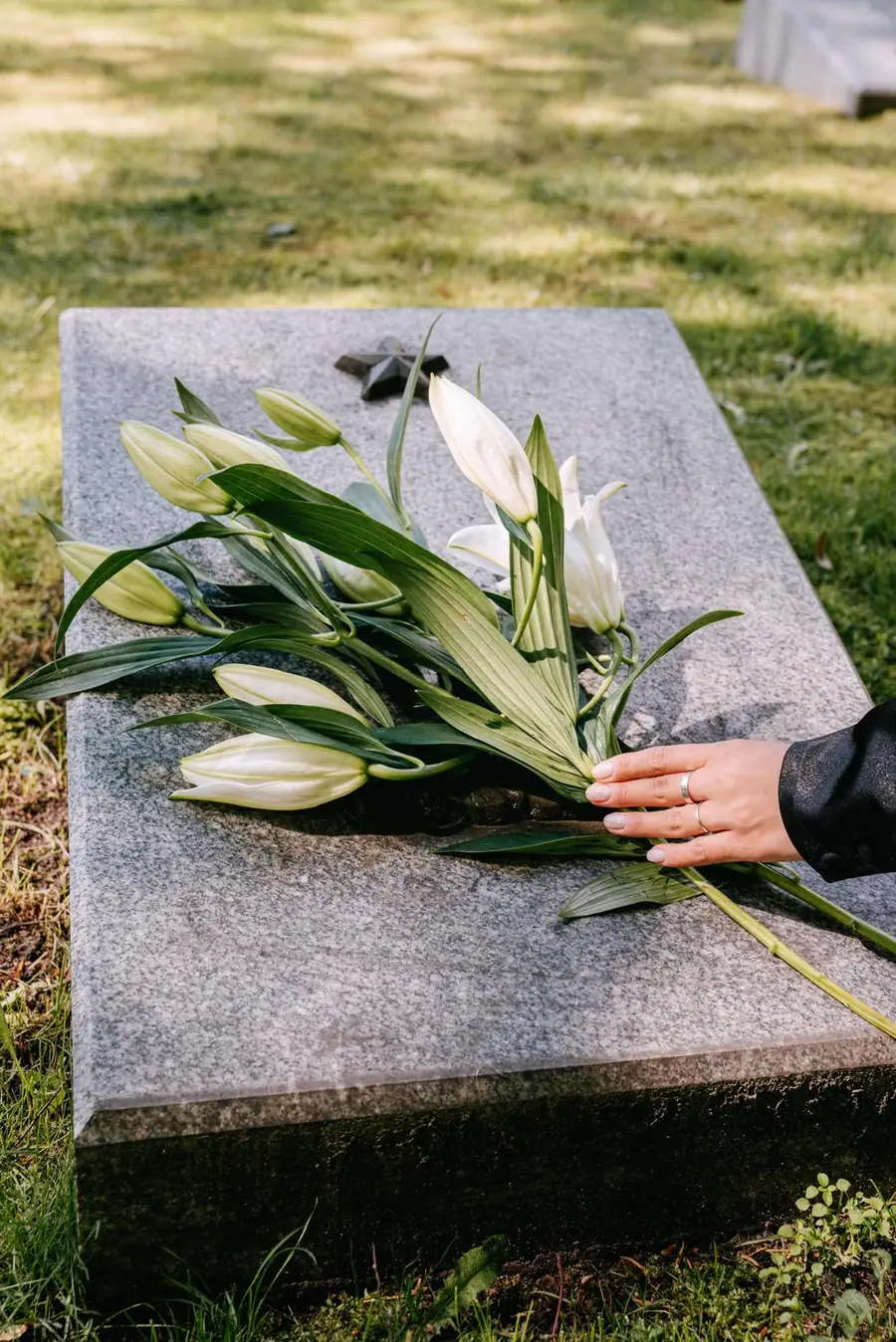 White lilies on a granite flat marker